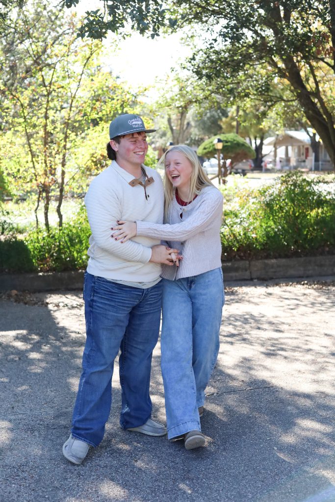 Young teen couple holding each other and smiling during a fall portrait session